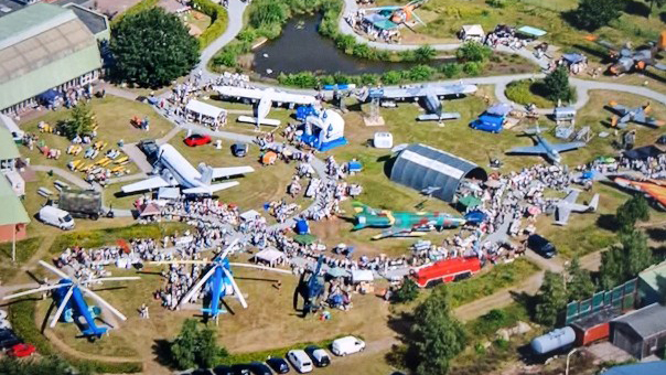 Flohmarkt zwischen Luftfahrzeugen mit buntem Programm